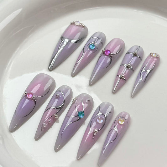 Uñas postizas en tonos pastel hechas a mano con papel de plata y gemas