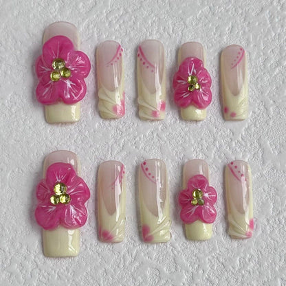 Ongles français délicats à coller avec des motifs floraux roses